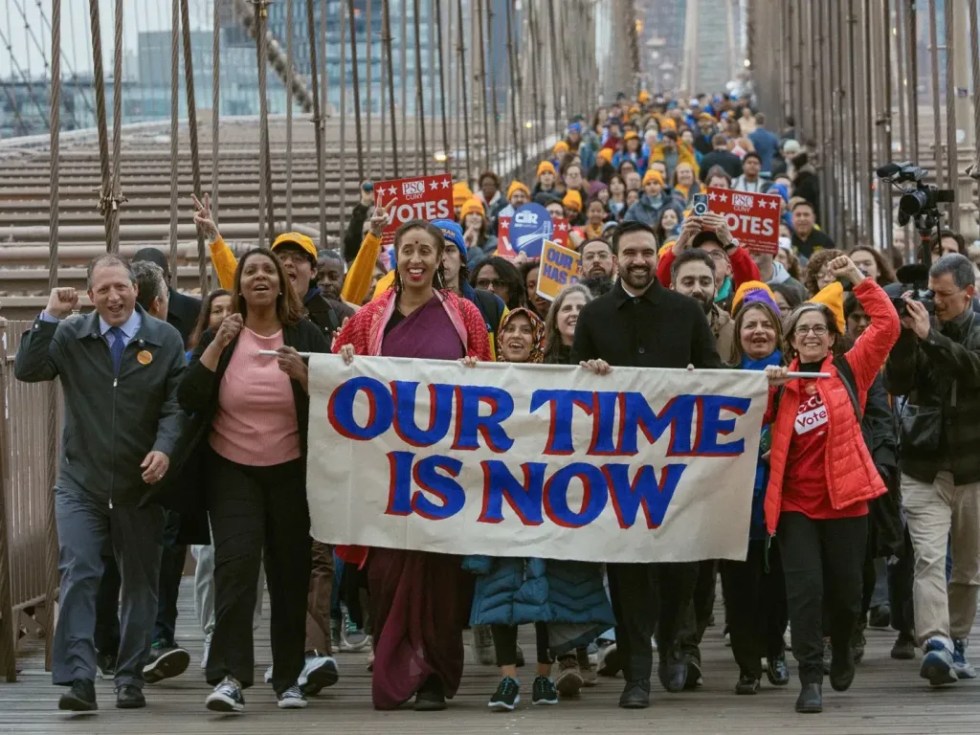 Fotografía tomada de la red social X de la cuenta @ZohranKMamdani que muestra al demócrata Zohran Mamdani (c-d) cruzando el puente de Brooklyn durante un acto político este lunes, en Brooklyn (Estados Unidos). EFE/ @zohrankmamdani